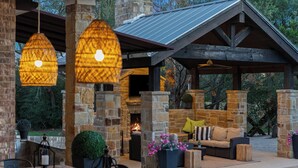 An outdoor patio with stone pillars, a fire pit, and a pool. - Weekday deals Pool King Bed Giant games Single level Space Firepit Min DT Austin (Austin)