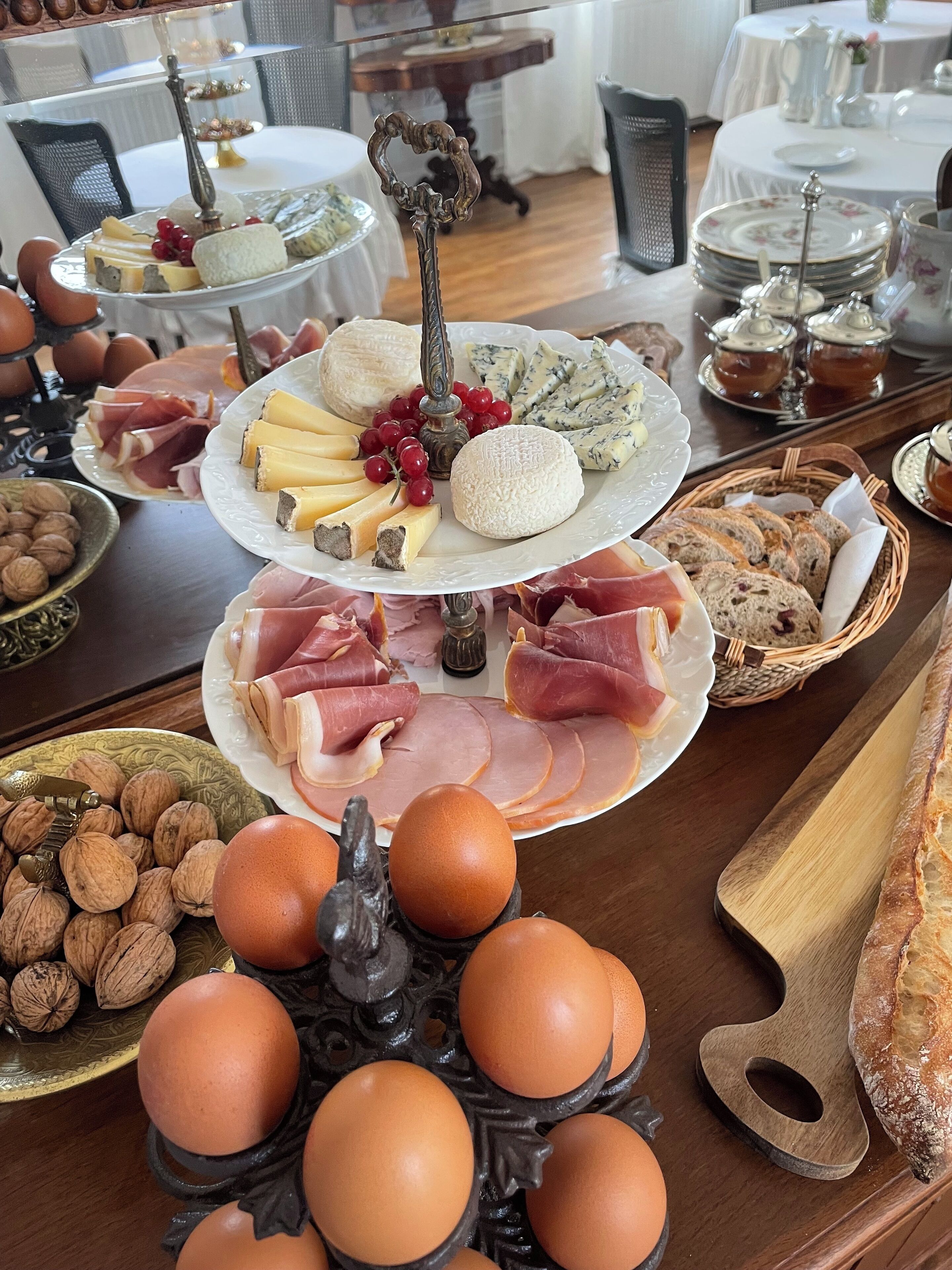 A buffet table with various food items including cheeses, meats, and bread.