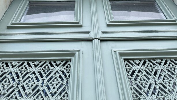 Fachada de edificio con esculturas ornamentales y un diseño de ventanas simétrico.