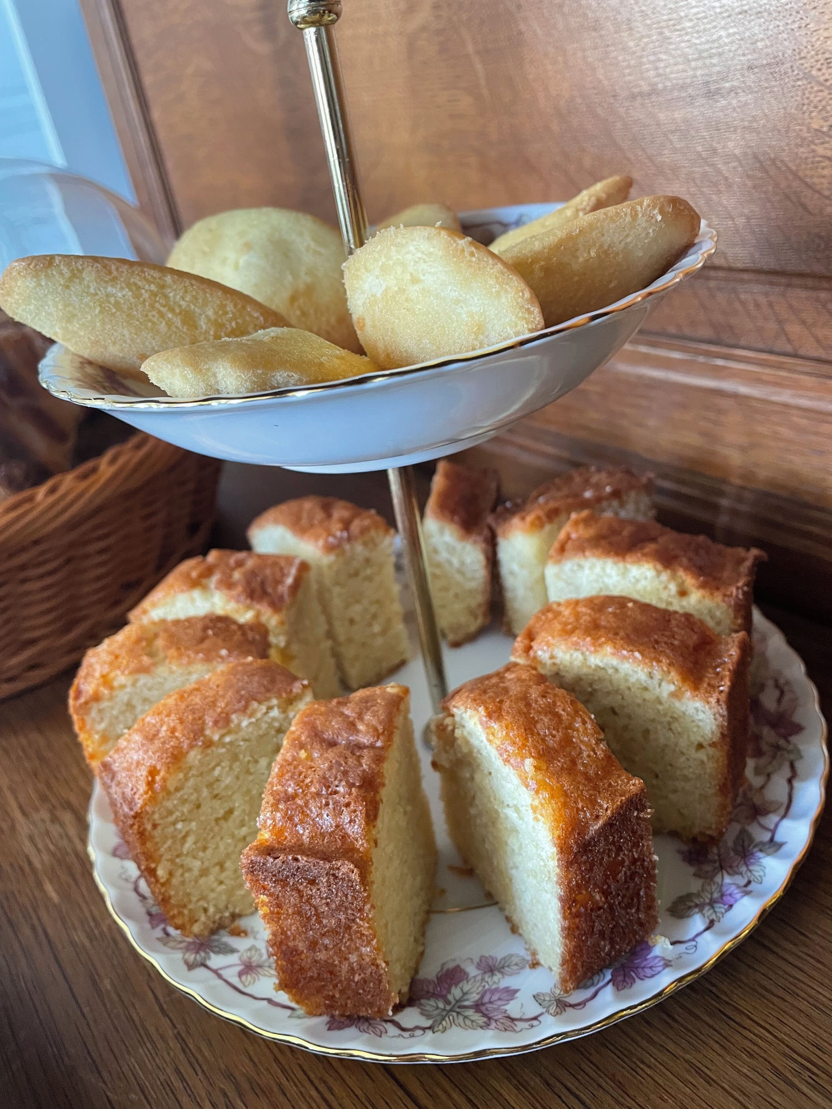 Un soporte para pasteles con un pastel y un plato de palitos de pan.