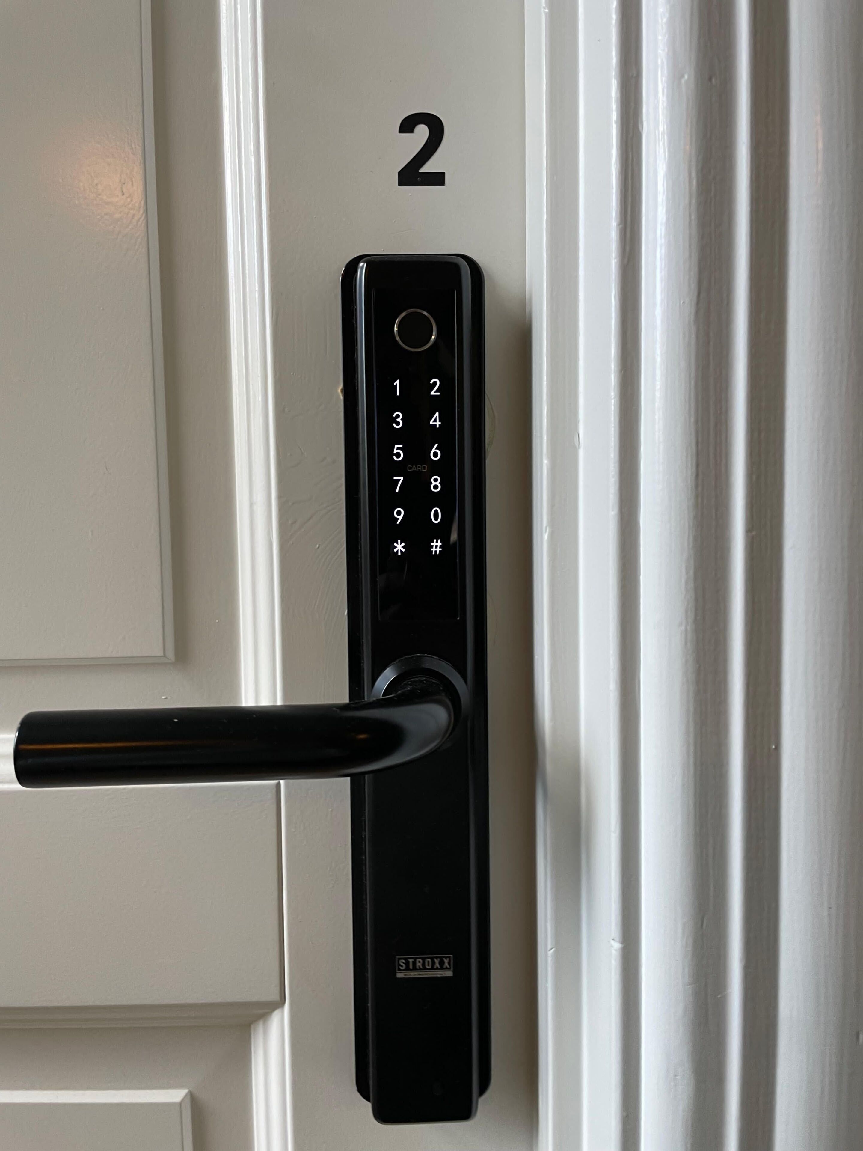 A numeric keypad door lock with a handle, labeled with the number 2.