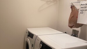 Une buanderie équipée de deux machines à laver à chargement frontal et d’un sèche-linge.
