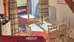 A cozy room with a wooden ceiling, a dining table with chairs, and a view of the outdoors. - Bright 6/7-bed apartment near town center and ski lifts (Morillon)