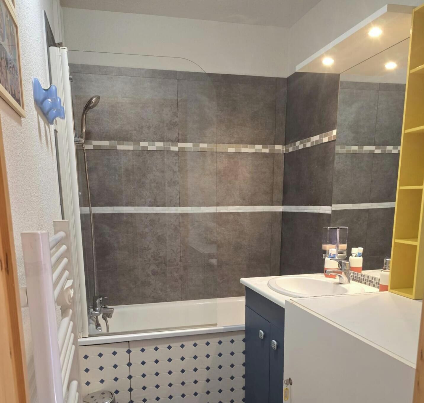 Une salle de bain équipée d’une baignoire, d’une douche et d’un lavabo avec des articles de toilette.
