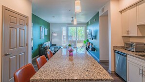 A modern kitchen with granite countertops, white cabinets, and a built-in dishwasher. - Walk To Stadium with Balcony-Pool-Gym-Parking-W/D (Glendale)