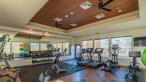 A gym with exercise equipment, a mirror, and large windows. - Walk To Stadium with Balcony-Pool-Gym-Parking-W/D (Glendale)