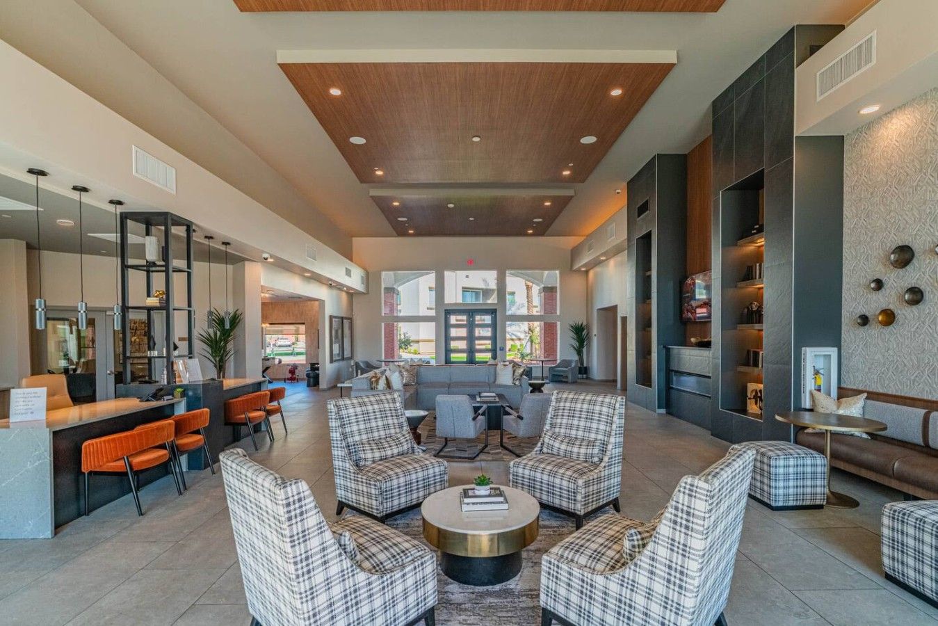 A spacious lobby with a reception desk, seating area, and a view of the outside.