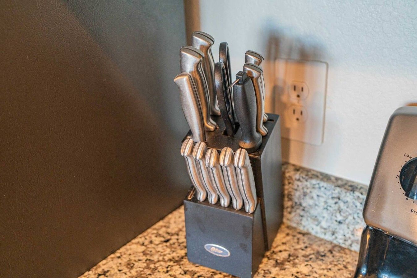 Un plan de travail de cuisine avec un bloc à couteaux contenant plusieurs couteaux.