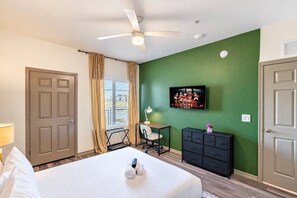 Ein Hotelzimmer mit einem Bett, einem Schreibtisch, einem Sessel, einem Fernseher und einem Kleiderschrank.