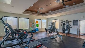 A gym with treadmills, weight machines, and exercise balls.