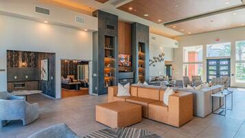 A spacious lobby with a seating area, a fireplace, and a large window providing natural light.