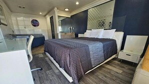 Une chambre à coucher moderne avec un grand lit, un bureau et une coiffeuse.