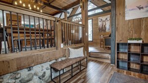 Een rustiek interieur met een stenen muur, een houten bank en een open haard.