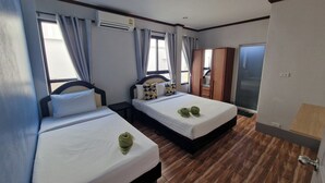 Camera d'albergo con due letti, un condizionatore d'aria, un armadio e una porta con maniglia.