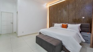 Ein modernes Schlafzimmer mit einem großen Bett, einer Wandvertäfelung aus Holz und einer Bank.