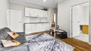 Eine moderne Wohnung mit Küche, einem Wohnbereich mit Sofa und Couchtisch sowie einem separaten Badezimmer.