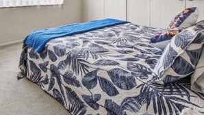 Ein Schlafzimmer mit Bett, Fenster und Kleiderschrank.