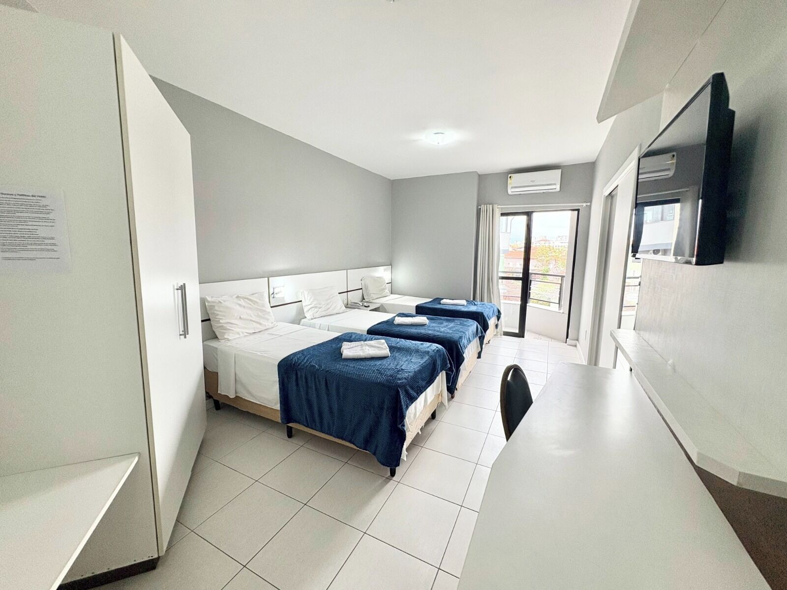 Quarto triplo conforto, sacada, vista parcial para o mar | Escrivaninha, espaço de trabalho para notebook, Wi-Fi de cortesia