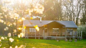 A cabin with a porch, outdoor seating, and a wheelbarrow.