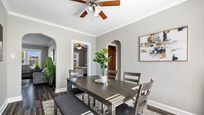 A dining area with a wooden table, chairs, and a ceiling fan. - Serene Suburban Stay: Family-Friendly w/EZ Parking (Berwyn)