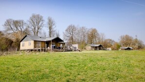 Une propriété rurale comprenant une maison principale, un petit chalet et une cour clôturée.