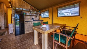 Un intérieur en bois comprenant un coin cuisine, une table à manger et des chaises.
