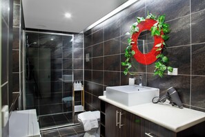 A modern bathroom with a large mirror, a white sink, and a shower area. - Quirky on Oakstreet located inParkville , great place for foodies and travellers (Parkville)