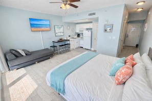 A bedroom with a bed, a sofa, a desk, and a kitchenette. - Gulf-Front Studio Sleeps 2 w/ Resort Amenities! (Panama City Beach)