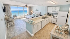 A compact hotel room with a balcony, a kitchenette, and a bed with a view of the ocean. - Beachfront Studio w/ Bunks Sleeps 4 at Majestic! (Panama City Beach)