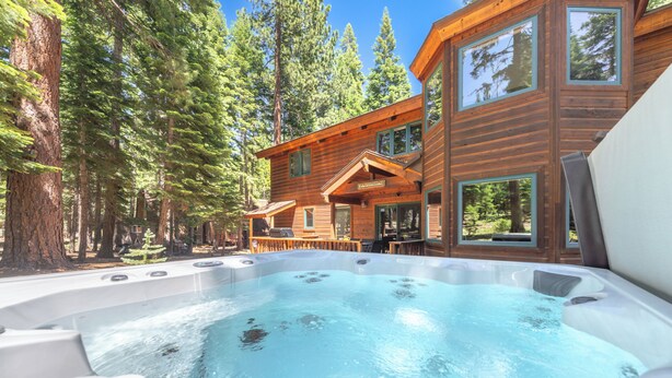 A hot tub in a forested area with a wooden cabin in the background. - Spacious 5BR Carnelian Grand Retreat, Hot Tub, perfect for the whole family (Carnelian Bay)