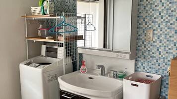 A compact kitchen with a washing machine, a sink, and storage drawers.