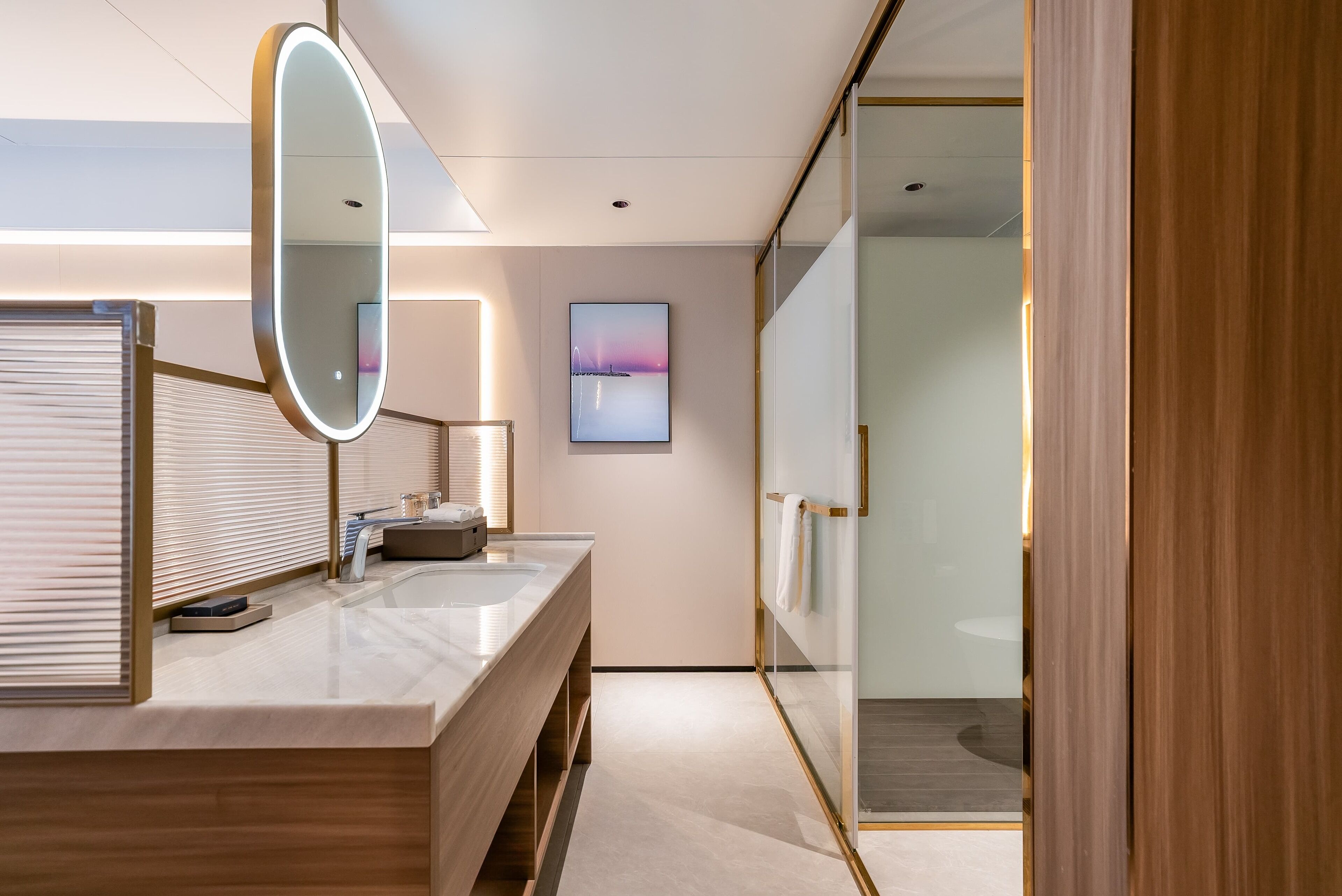 A modern bathroom with a large mirror, a sink, and a towel rack.