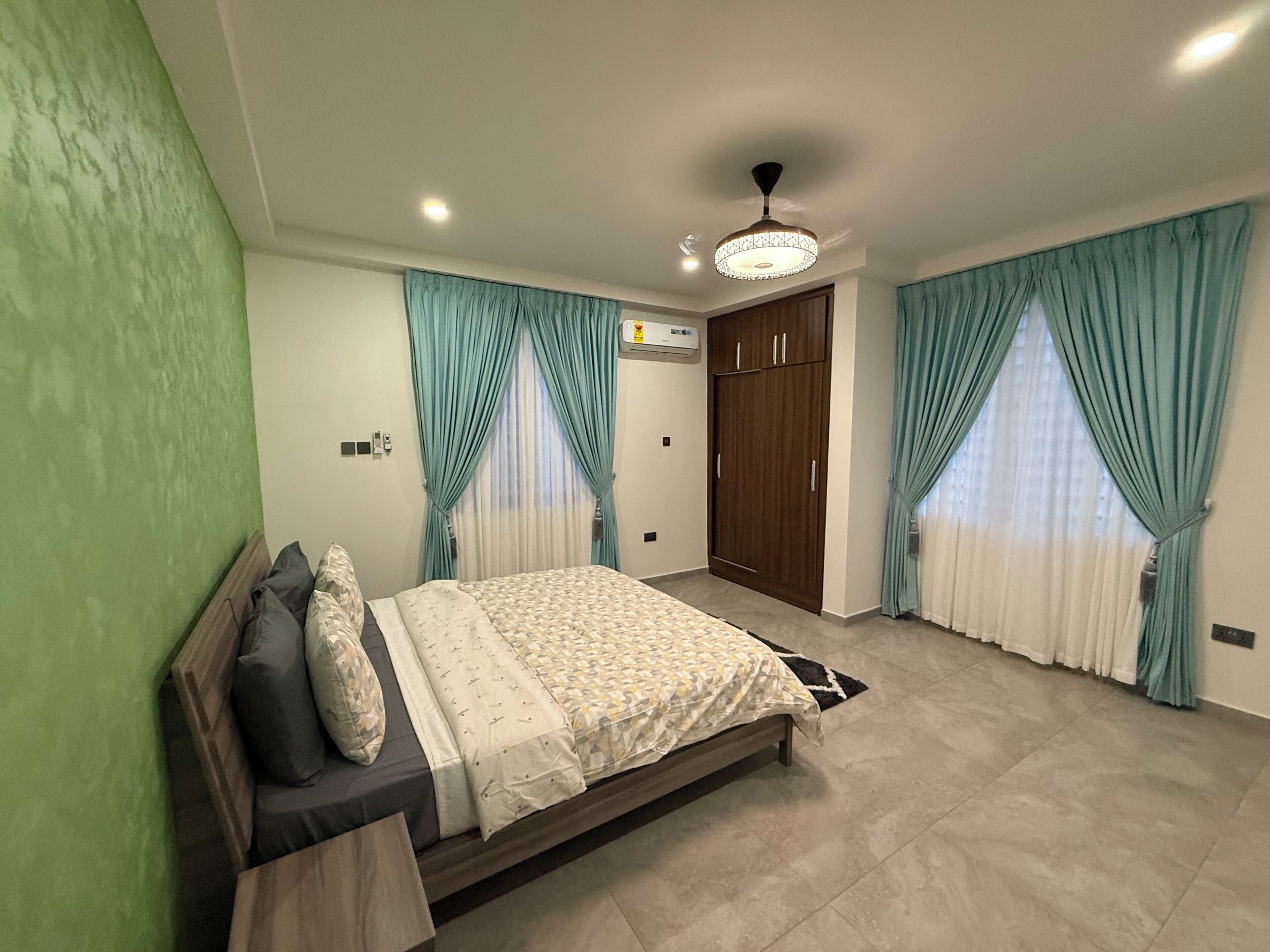 Une chambre à coucher avec un lit, une armoire et des rideaux.