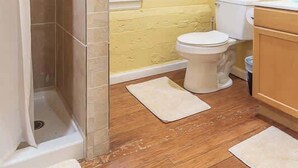 Un baño con ducha, inodoro y lavabo.