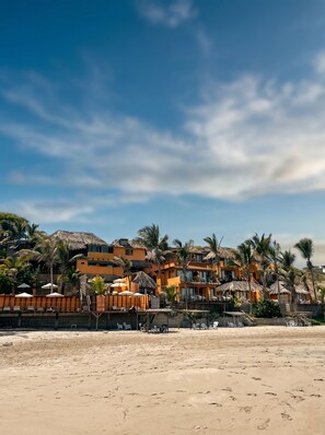 En la playa, playa de arena blanca, camastros y sombrillas 