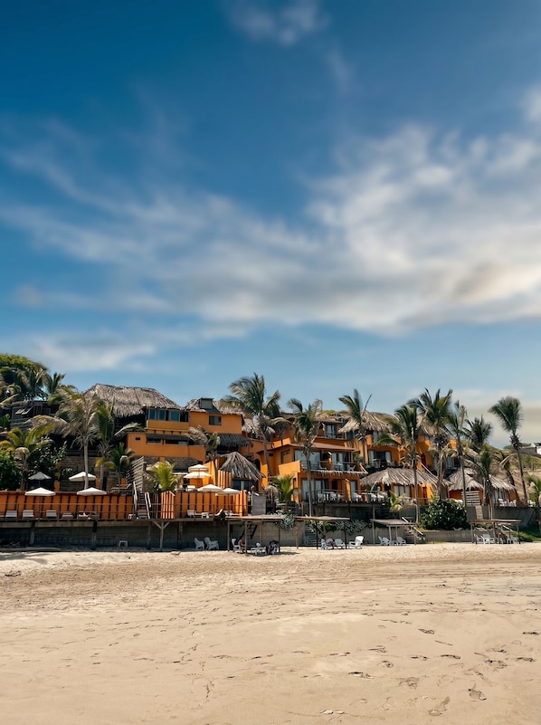 On the beach, white sand, sun loungers, beach umbrellas