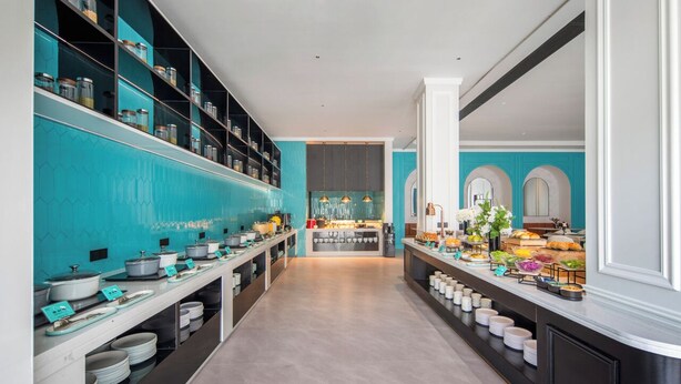 A modern kitchen with a central island, built-in shelves, and a buffet setup. - Xana Hotel Guilin Wuyue Square  Branch (Guilin)