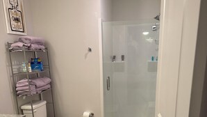 Kylpyhuone, jossa on wc, suihku, pyyheteline ja pesuallas.