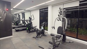 Ein modernes Fitnessstudio mit verschiedenen Trainingsgeräten, darunter Laufbänder, Ergometer und Kraftgeräte.