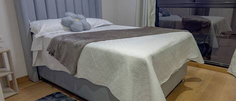 Tabla de planchar con plancha, internet y ropa de cama