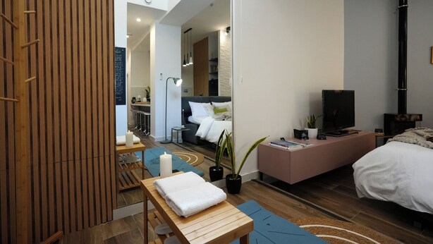 Een moderne slaapkamer met een bed, nachtkastje en een televisie.