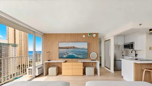 Ein modernes Apartment mit Balkon, einer Küche und einem großen Fernsehbildschirm, das eine schöne Aussicht zeigt.