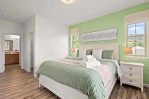 Une chambre à coucher avec un lit, une table de chevet, une fenêtre et une vue sur l’extérieur.