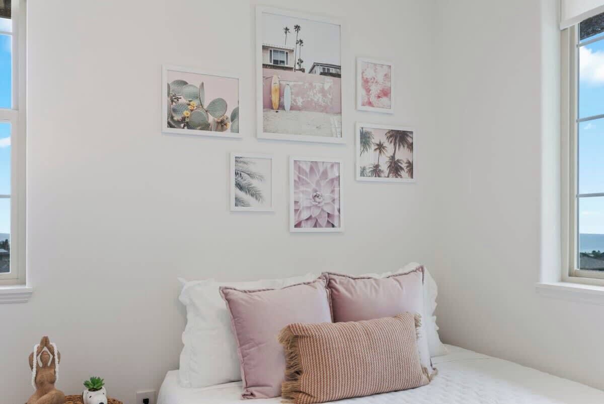 Un dormitorio con cama, almohadas y decoración en la pared.
