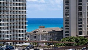 A high-rise building with multiple balconies overlooking a clear blue ocean. - @ Marbella Lane - Vibrant and Refreshing Studio (Honolulu)