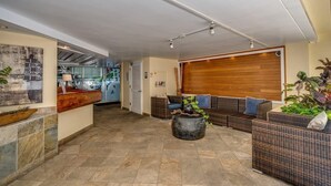 Eine großzügige Lobby mit Empfangsschalter, Sitzbereich und einer großen Holztür.