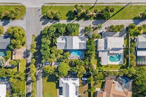 An aerial view of a residential area with houses, a swimming pool, and palm trees. - 502 Colony Street (Melbourne Beach)