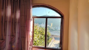 Una habitación con un amplio ventanal que da a un puente y edificios a lo lejos.
