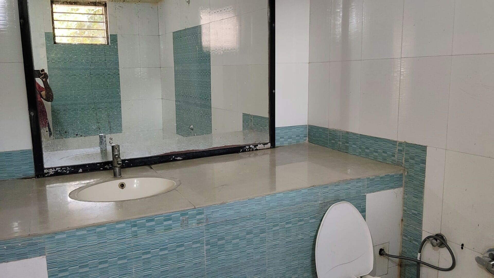 Une salle de bain avec un grand miroir, un lavabo et des toilettes.