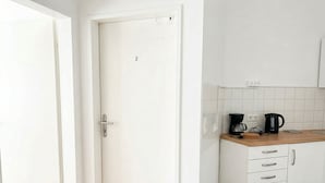 A modern kitchen with white cabinets, a wooden countertop, and a coffee maker. - Lovely 3BR Apt With Balcony Rennweg (Vienna)